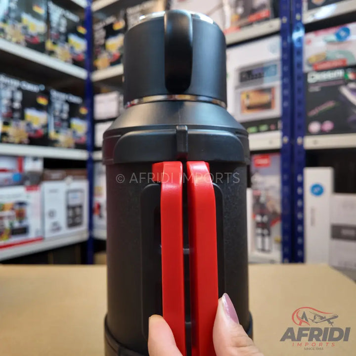 Black and red portable blender with a handle.