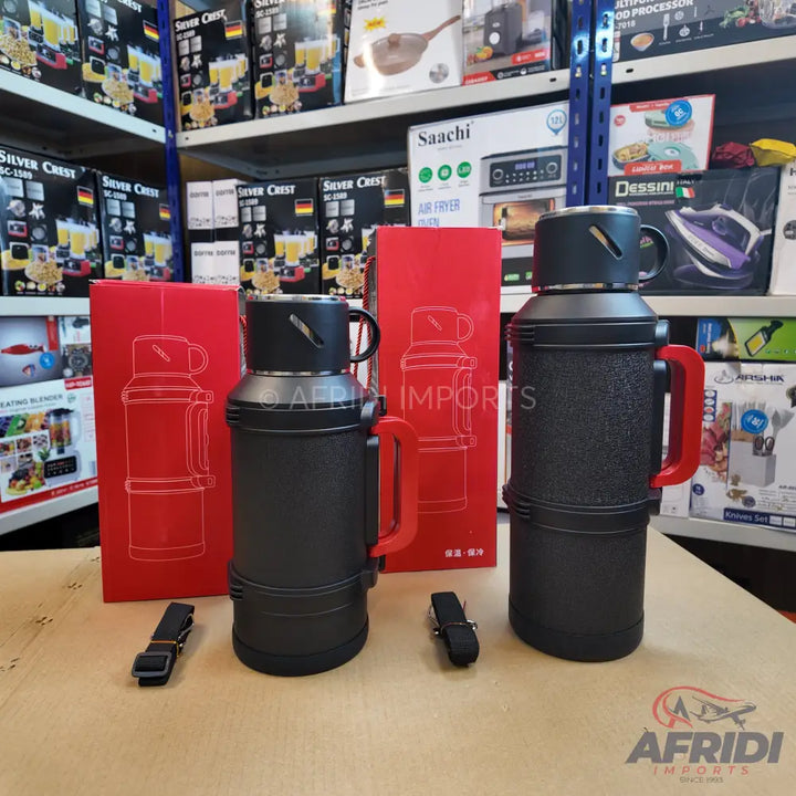 Two black thermal flasks with red handles and accompanying red packaging.