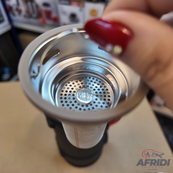 A metal mesh tea infuser with a silver-colored, perforated bottom.