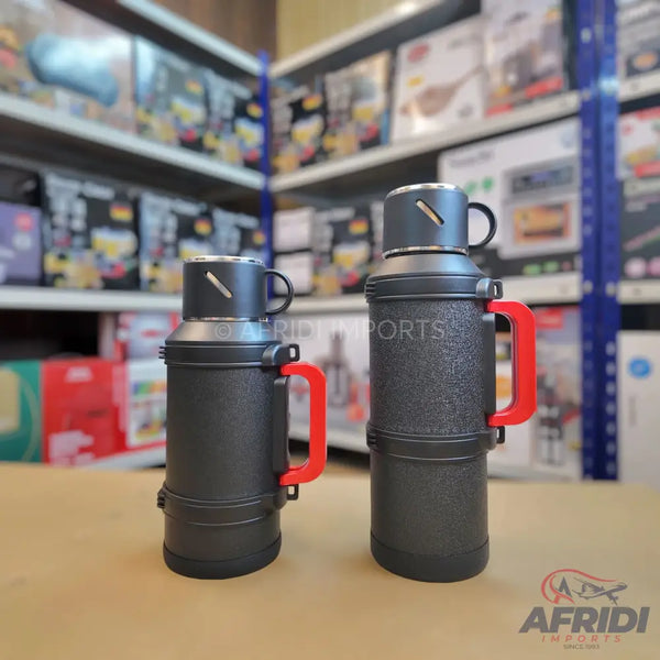 Two dark grey insulated thermoses with red handles and integrated cups.