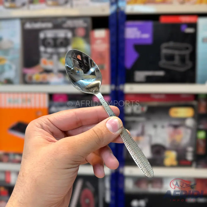 Shiny silver-colored metal spoon with a patterned handle.