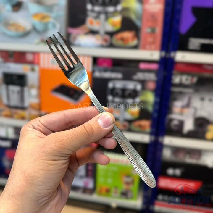 Silver metal dinner fork with a decorative handle.