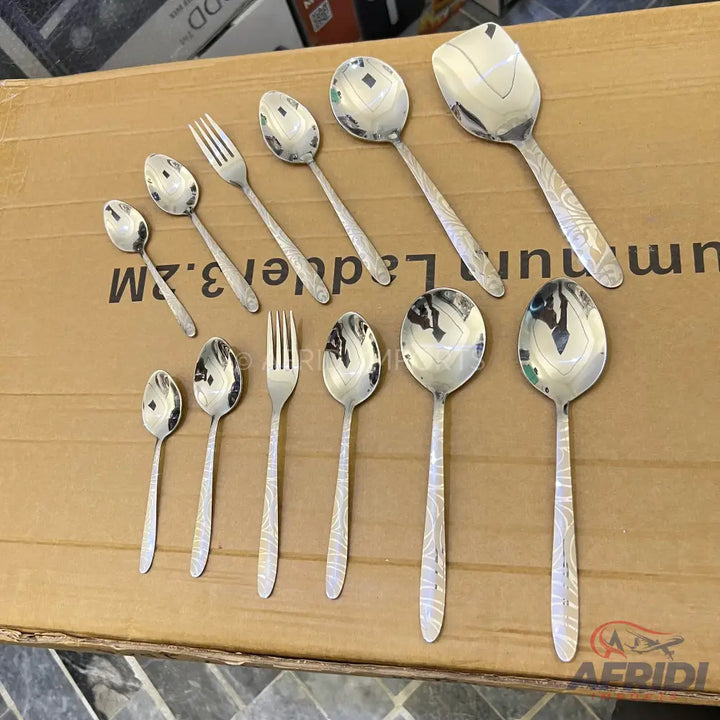 A set of shiny silver-colored spoons and forks with etched handles.
