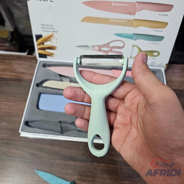 A mint green Y-peeler with a stainless steel blade.
