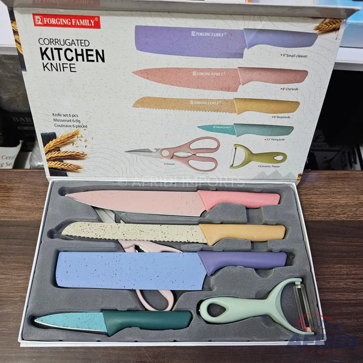 A boxed set of colorful kitchen knives, a peeler, and scissors.