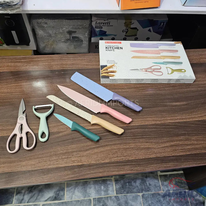 A pastel-colored kitchen knife set with matching peeler and scissors.