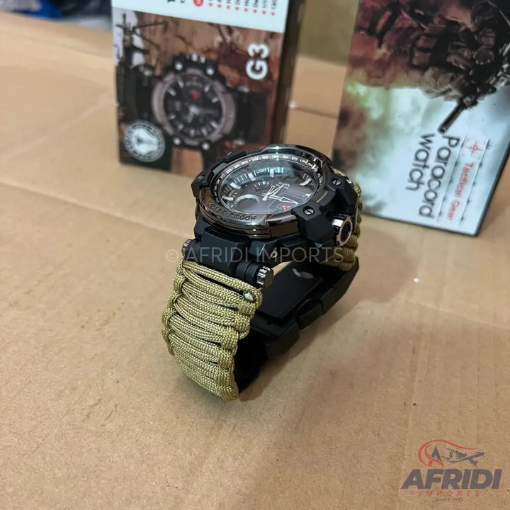 A black and silver tactical watch with a tan paracord band.