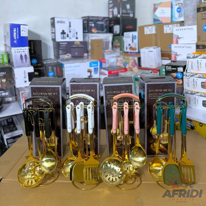 Four sets of gold kitchen utensils with colored handles and matching stands.