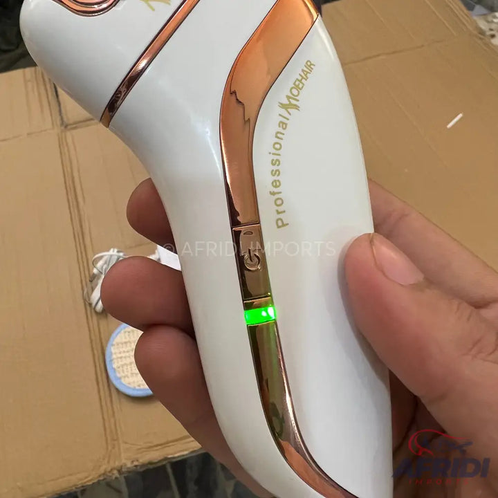 White and rose gold electric hair removal device with a glowing green indicator light.