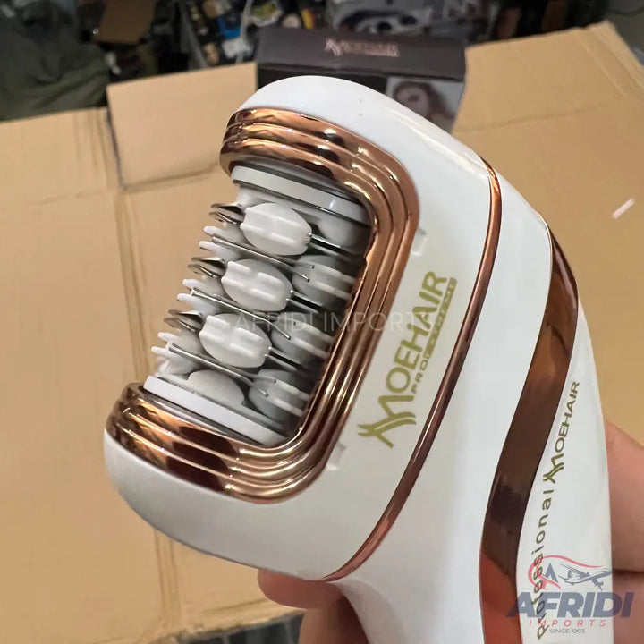 White and rose gold handheld hair treatment device with comb-like rollers.
