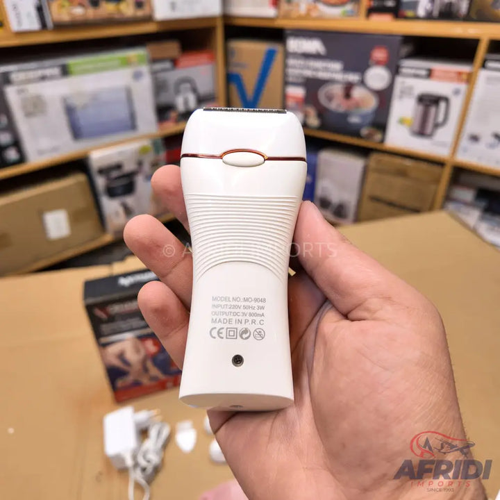 White electric shaver or epilator with a gold-colored accent band.