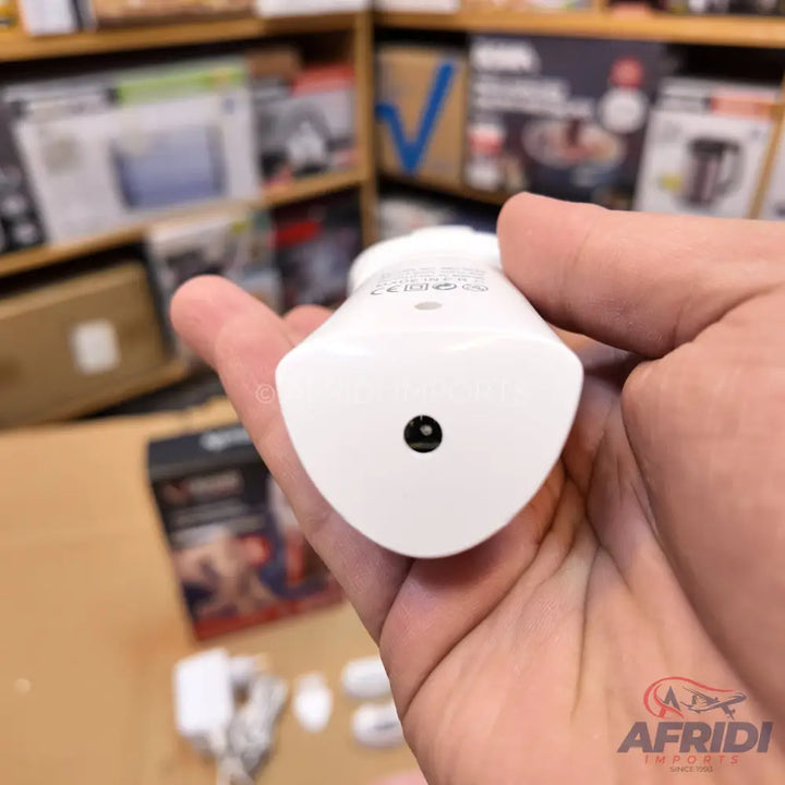 A white, compact smart plug or adapter with a circular pinhole reset button.