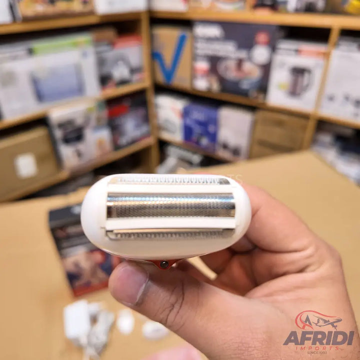 A white electric shaver with two silver foil heads.