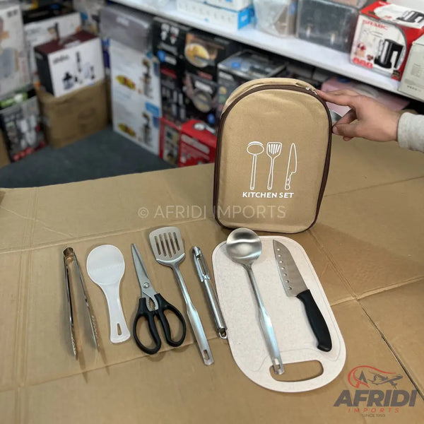 A portable kitchen utensil set, including tongs, a rice spoon, scissors, a slotted spatula, a peeler, a ladle, and a knife with a cutting board, all contained within a beige zippered pouch.