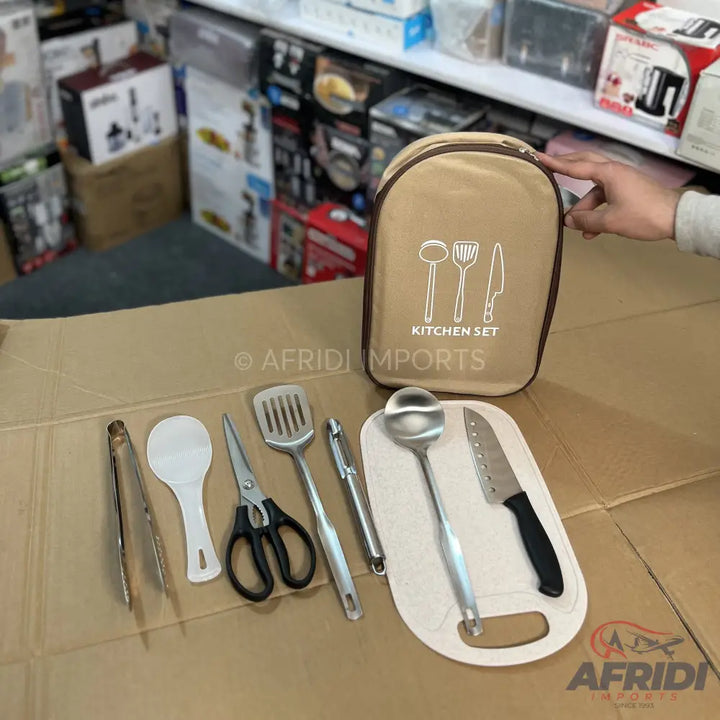 A portable kitchen utensil set, including tongs, a rice spoon, scissors, a slotted spatula, a peeler, a ladle, and a knife with a cutting board, all contained within a beige zippered pouch.
