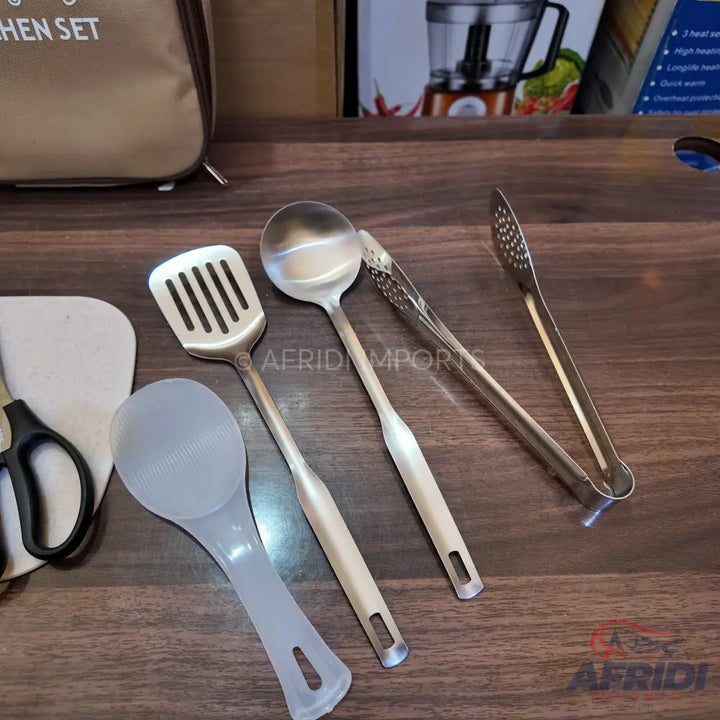 A set of stainless steel and plastic kitchen utensils, including a slotted spatula, ladle, tongs, and a rice paddle.