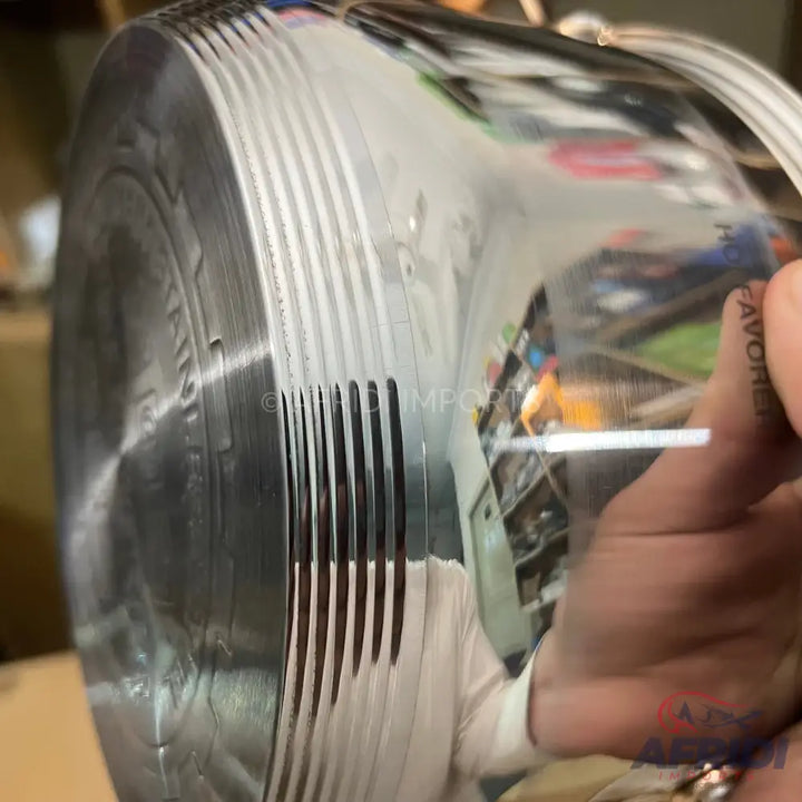 Roll of reflective, possibly metallic, material with a ribbed or corrugated texture.