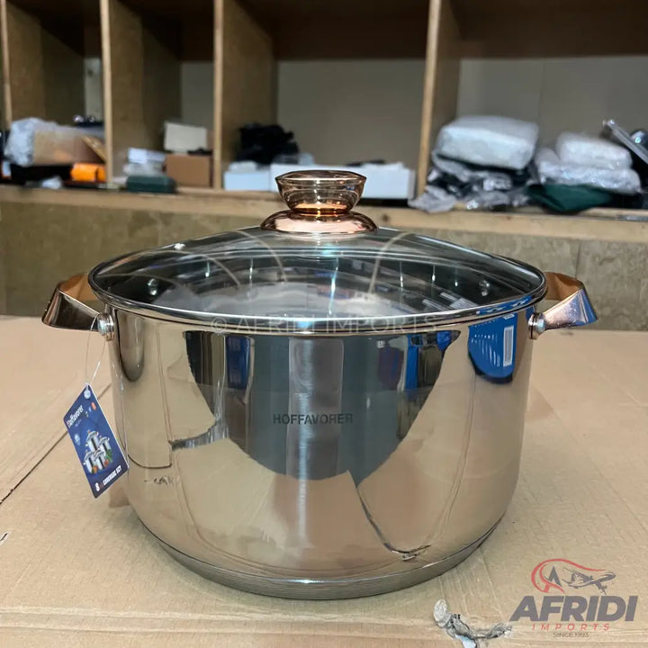 Stainless steel cooking pot with a glass lid and rose gold-colored handles.