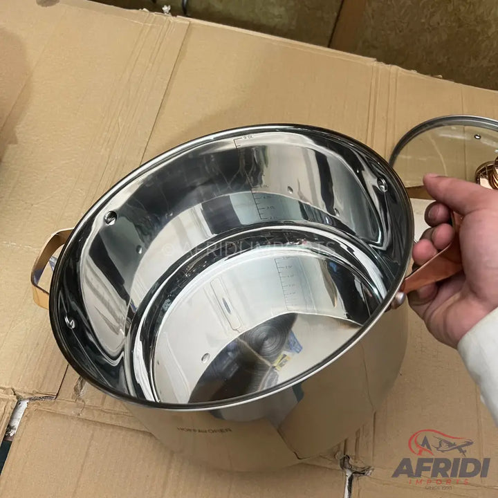 Stainless steel pot with copper-colored handles and volume markings.