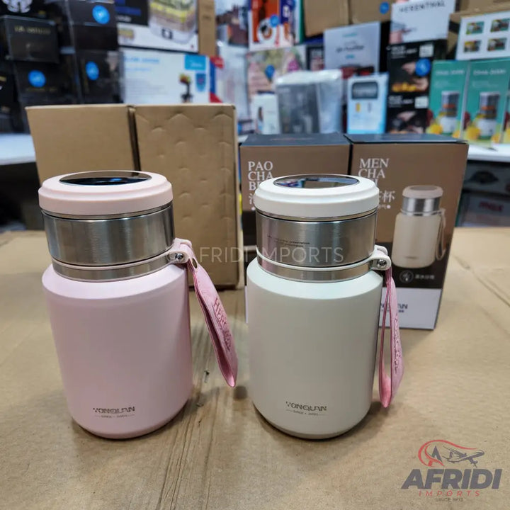 Two insulated stainless steel water bottles with a digital temperature display on the lid, one in light pink and one in off-white, each with a pink carrying strap.