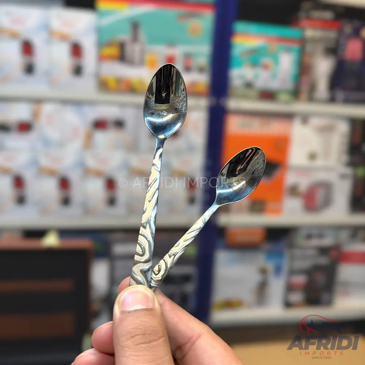Two stainless steel spoons with decorative, swirled handles.