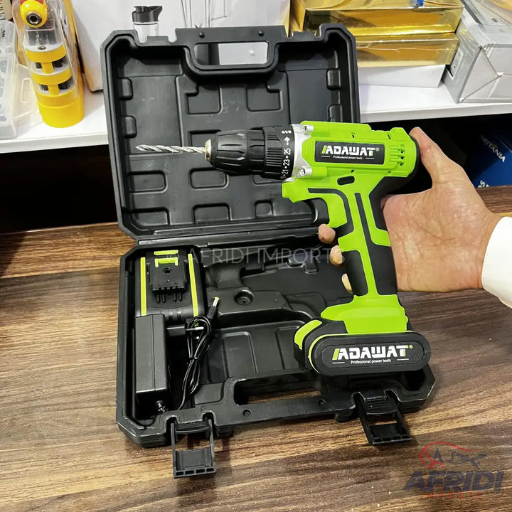 Green and black cordless drill with a battery, charger, and a drill bit, packaged in a black hard case.