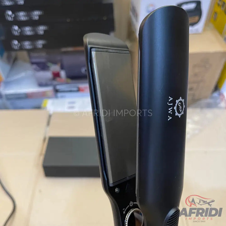 A closed, black hair straightener with a temperature dial.