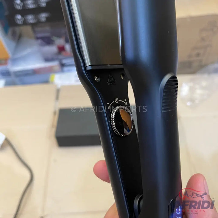 Black hair straightener with a circular temperature dial.