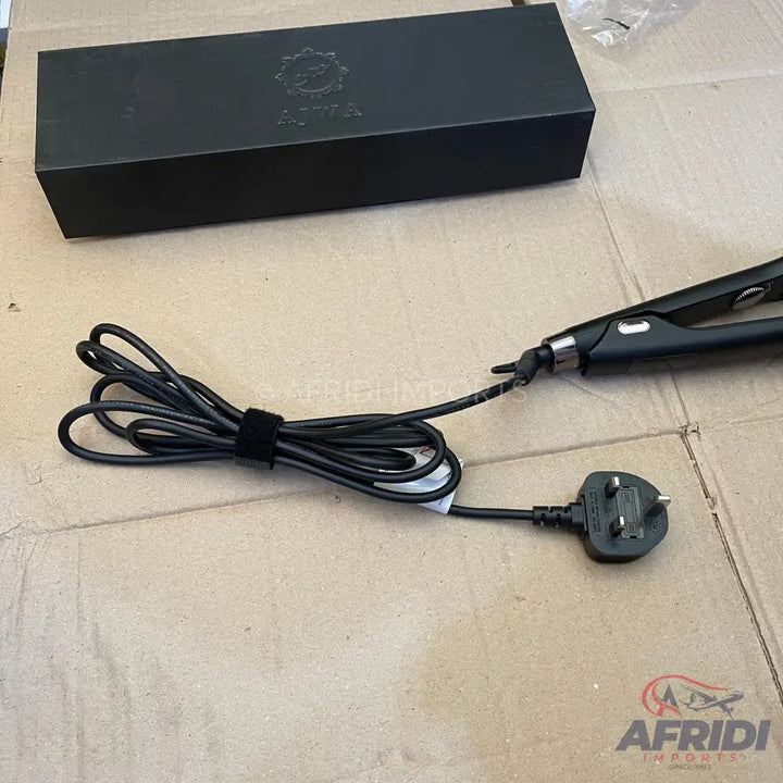 Black hair straightener with a UK plug and its packaging box.
