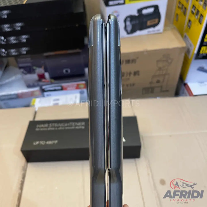 Closed dark gray hair straightener with shiny metallic plates.