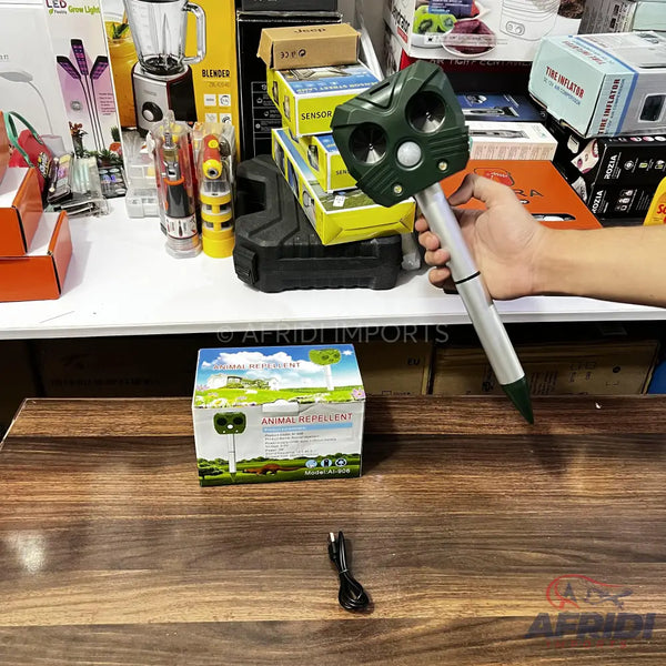 Green and silver ultrasonic animal repellent with a ground stake.