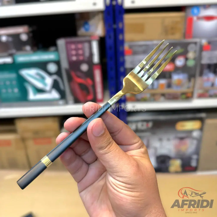 A black and gold stainless steel dining fork.