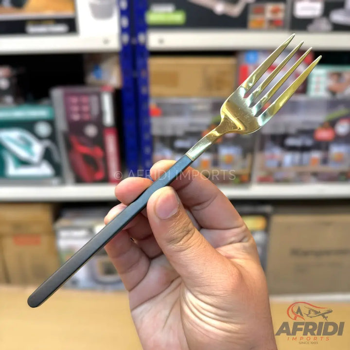 A black-handled fork with a golden head.