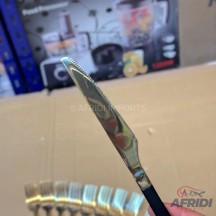 A silver-bladed steak knife with a serrated edge and a black handle.