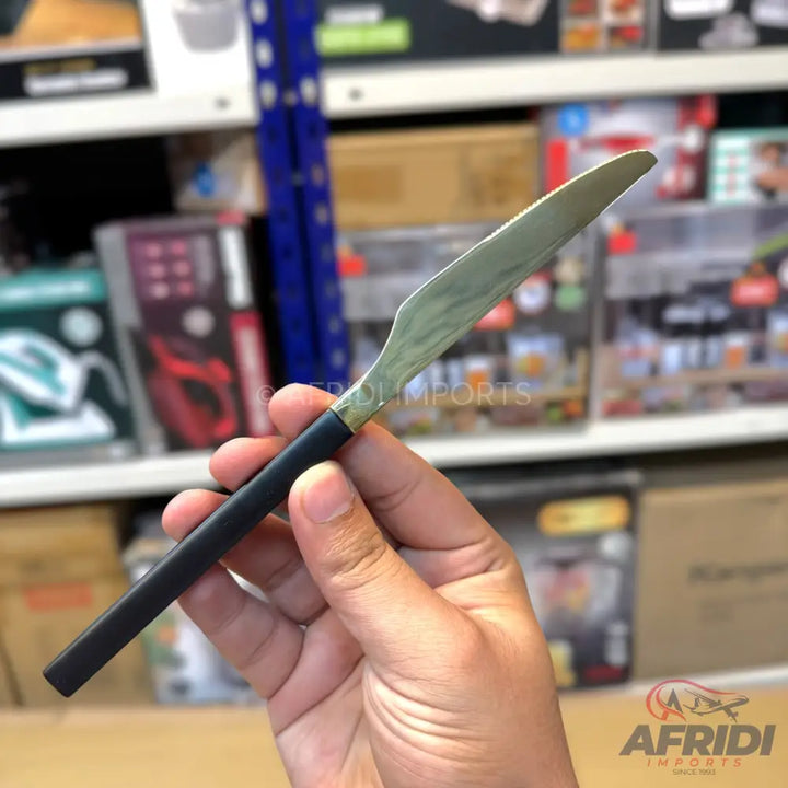A stainless steel butter knife with a black handle.