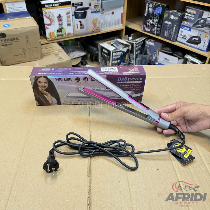 A hair straightener with pink plates and a gray body, accompanied by its power cord with a two-pronged plug.