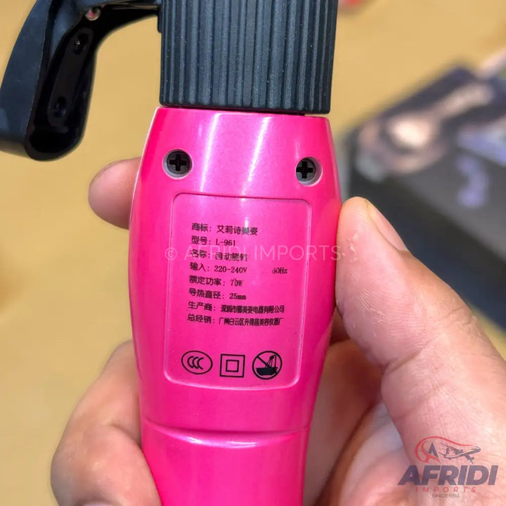A pink hair curling iron with product specifications.