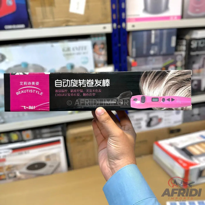 Pink automatic rotating hair curler in a black box.