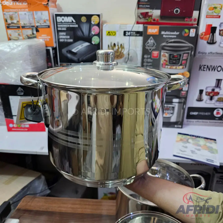 Shiny stainless steel cooking pot with a glass lid.