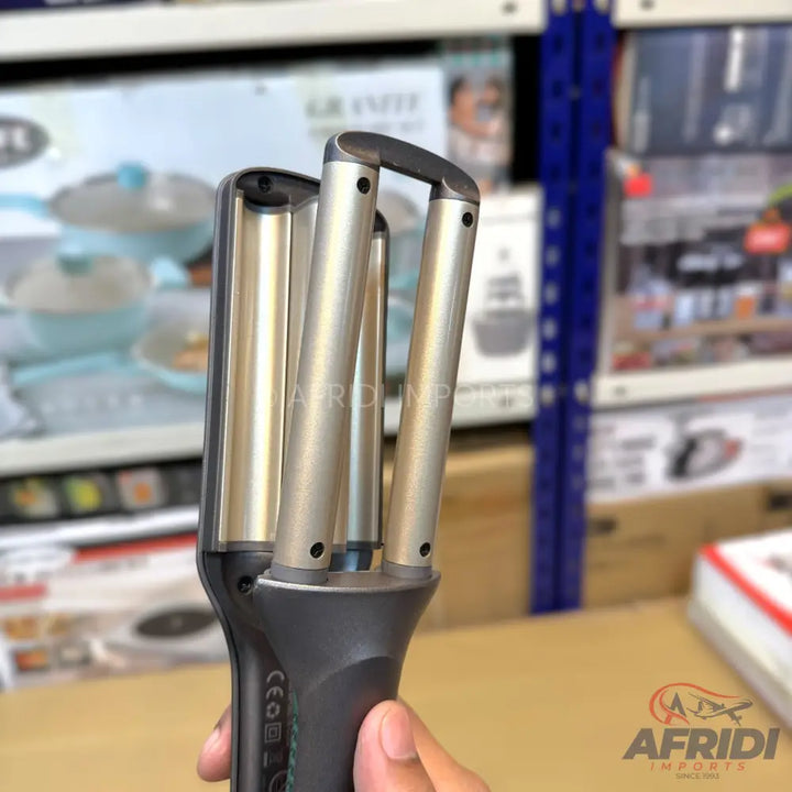 Triple barrel hair waver with gold-colored ceramic heating elements.