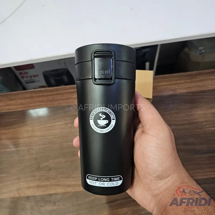 Black stainless steel travel mug with a secure flip-top lid.