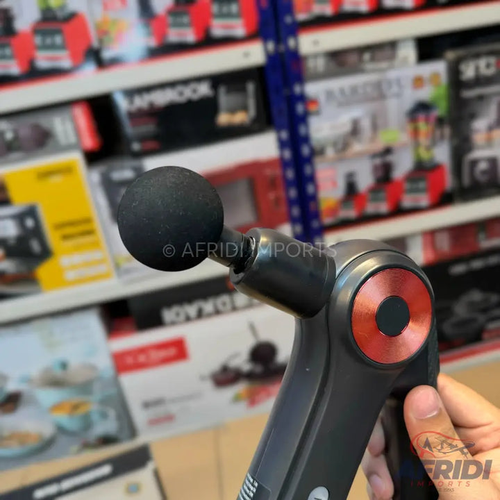 Handheld percussive massage gun with a spherical attachment.