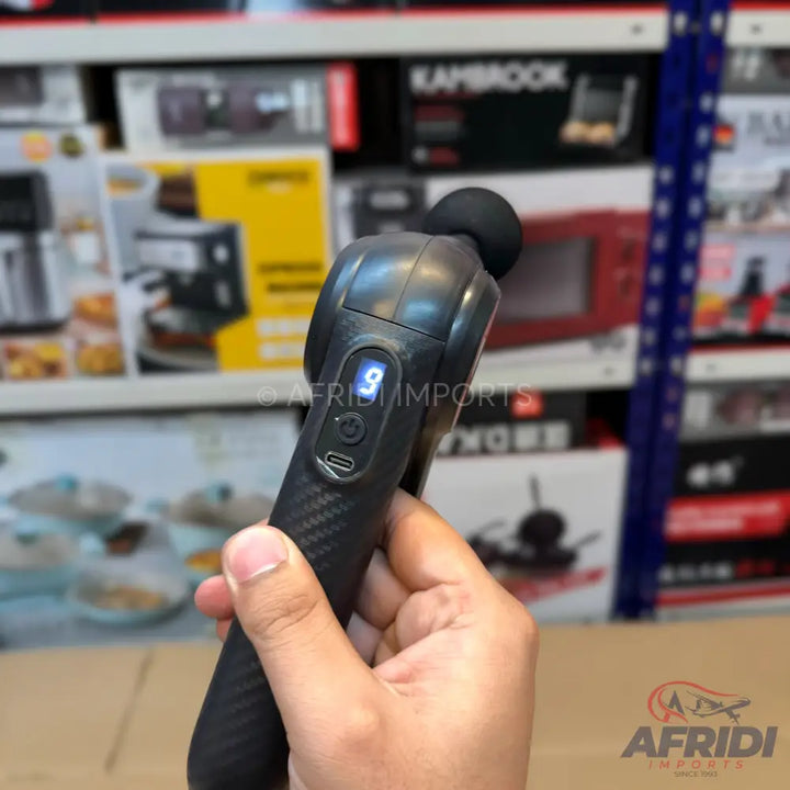 Black handheld massage gun with a digital display showing ’9’’ and a USB-C charging port.