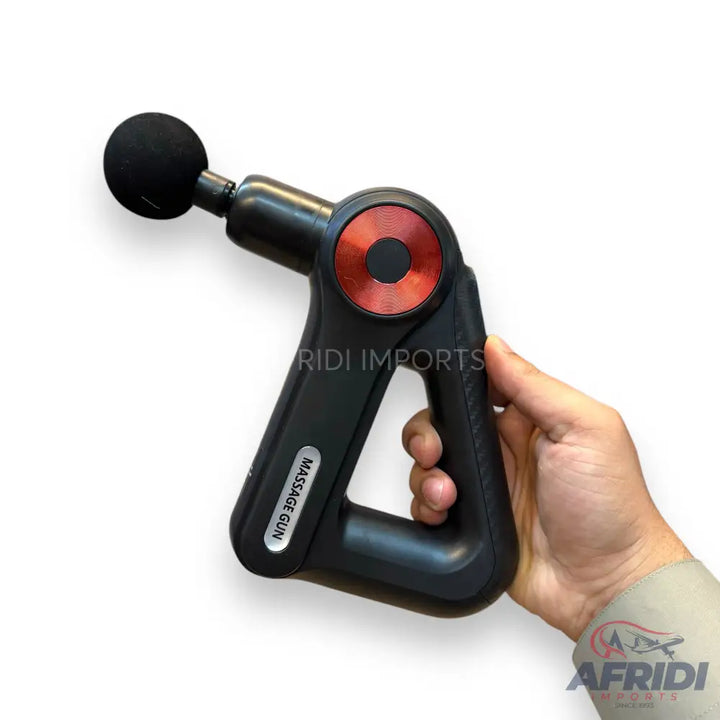 A black, handheld percussive massage gun with a round, red control panel and a spherical massage head.