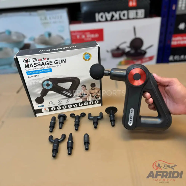 Black massage gun with red accents and a set of interchangeable massage heads.