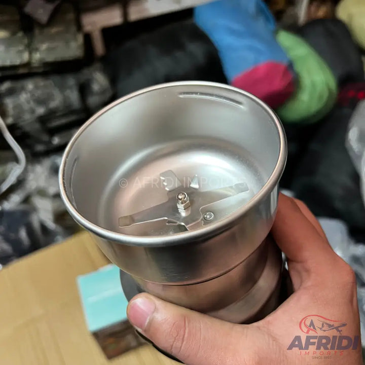 A silver-colored stainless steel electric coffee grinder with a two-bladed rotating cutter.