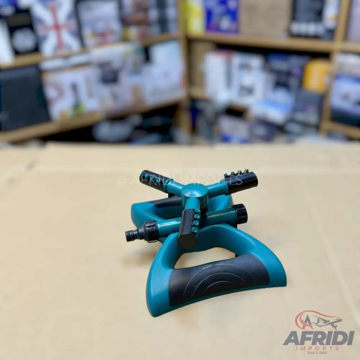 Teal and black three-arm rotating garden sprinkler.