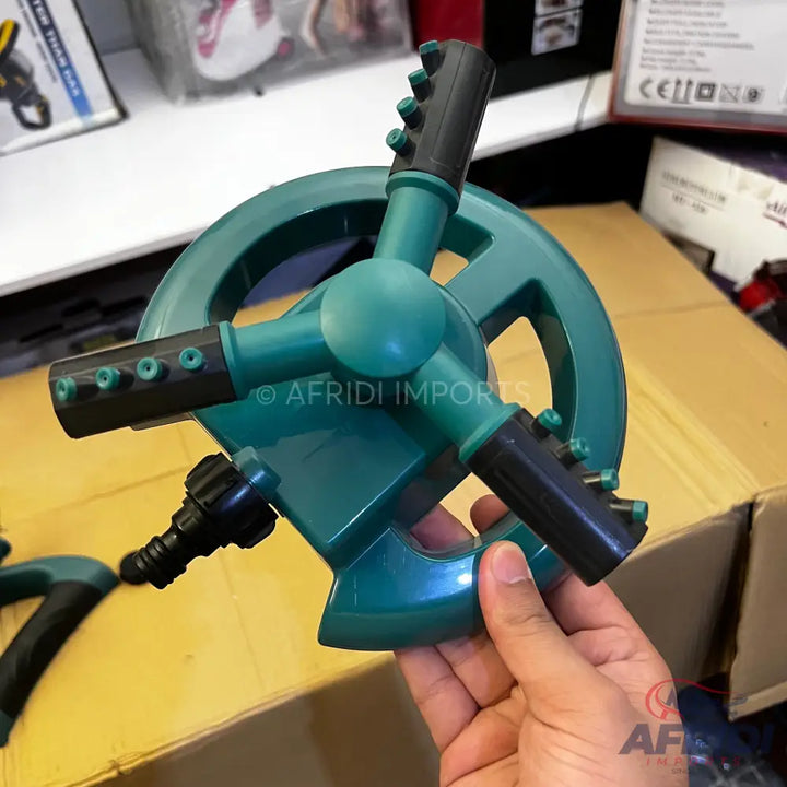 A three-arm rotating garden sprinkler with adjustable nozzles.