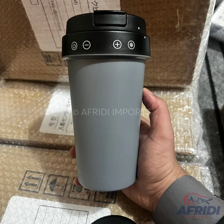 A gray travel mug with a black lid featuring power, minus, plus, and light-mode buttons.