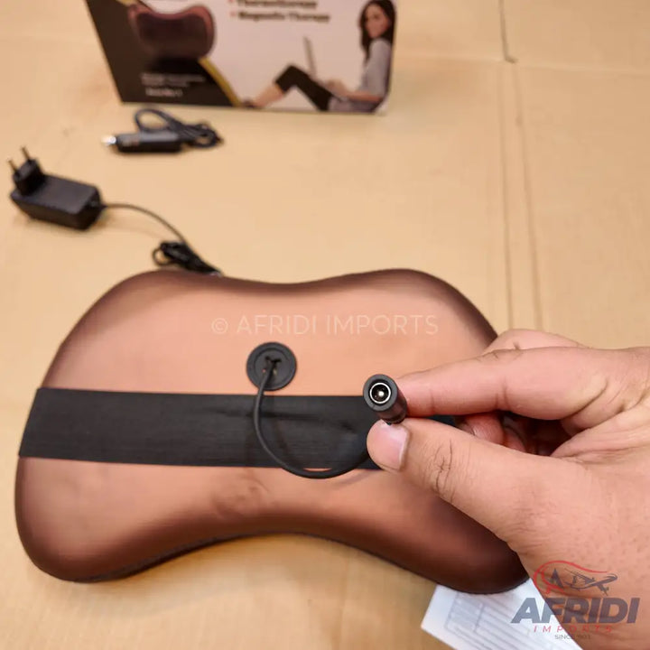 Brown, guitar-shaped massager with a power input.